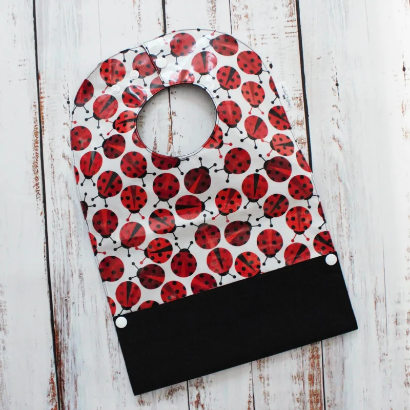 Bavoir en coton laminé – Coccinelles